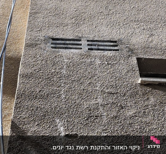 קיר בניין עם פתחי אוורור וחוטים